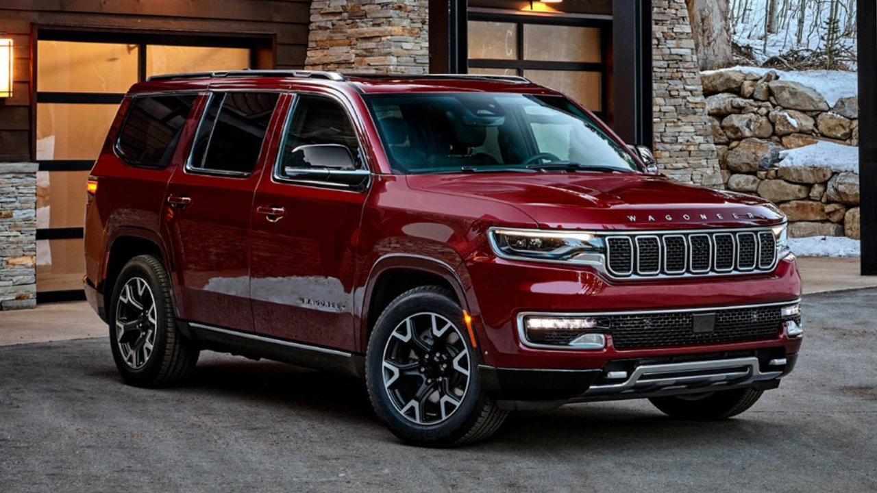 vue latérale avant d'un Jeep Wagoneer 2024 devant une maison moderne